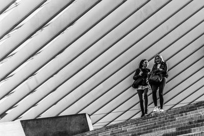 Full length of man and woman walking on staircase