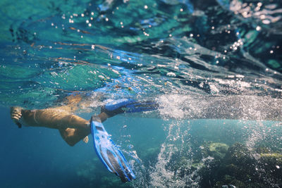 Woman with diving fins swimming undersea