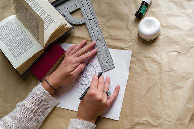 Hands of a woman writing an astrological chart