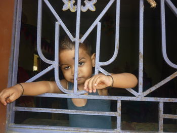 Portrait of girl looking through window