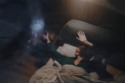 High angle view of friends sitting on bed