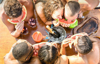 High angle view of friends eating watermelons