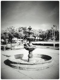 Fountain in swimming pool against sky