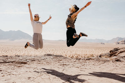 Full length of a young woman jumping on beach