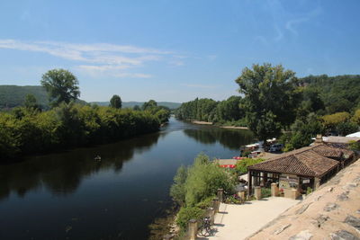 River amidst trees and buildings against sky