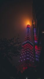 Low angle view of illuminated buildings against sky at night