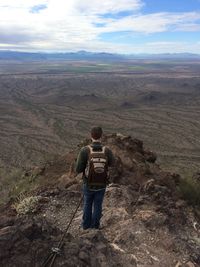 Rear view of hiker standing on mountain