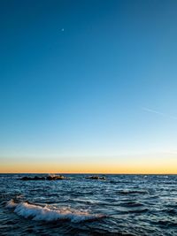 Scenic view of sea against clear blue sky