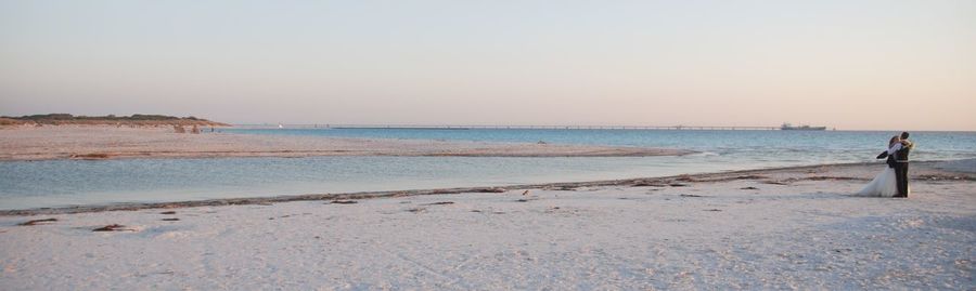 Scenic view of beach against clear sky during sunset