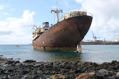 Boat on sea shore against sky