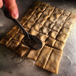 Cropped hand cutting pasta