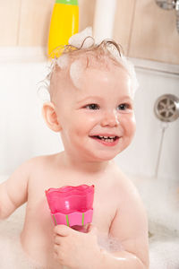 Girl playing with toys in bathtub