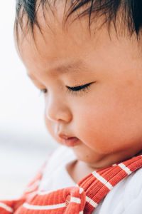 Close-up of cute baby boy sitting indoors