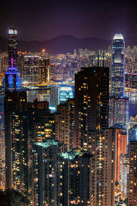 Illuminated buildings in city against sky at night