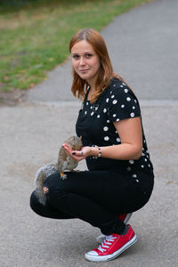 Portrait of smiling woman sitting on road