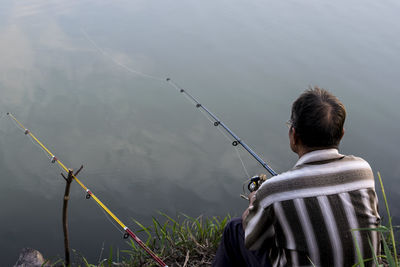 Rear view of man photographing against sky