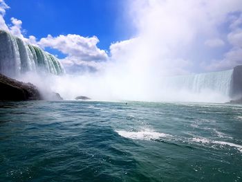 Scenic view of waterfall against sky