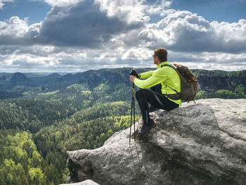 Ultralight runner on trail with tracking poles. tired sitting tourist with trekking poles in hand. 