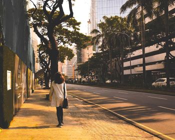 Rear view of woman walking on street in city