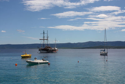 Sailboats sailing in sea against sky