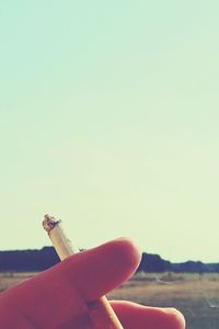 Cropped image of hand holding cigarette
