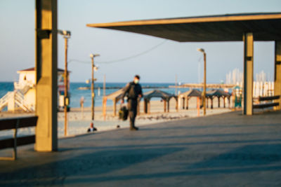 Man on beach in city against sky