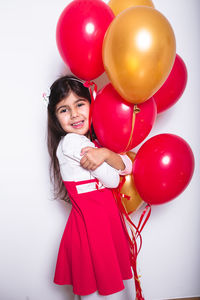 Portrait of smiling girl holding balloons