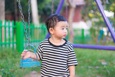 Boy holding swing at park