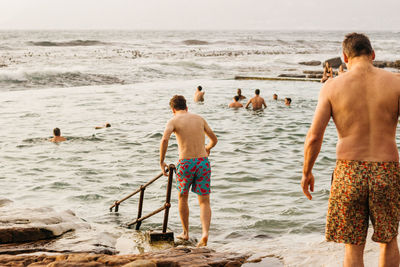 Rear view of two people on beach