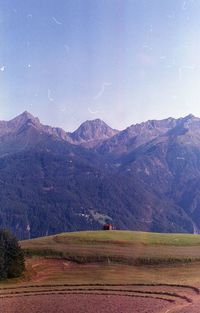 Scenic view of field and mountains against sky