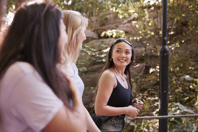 Three young female friends walking together and talking