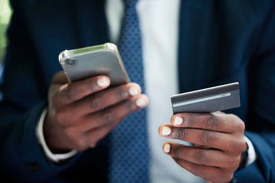 Midsection of man using mobile phone