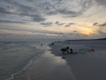 Big brother and baby sister playing at the beach