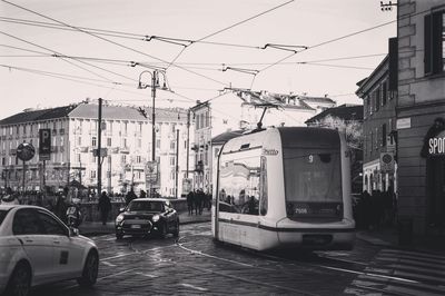 Cars on street in city against sky