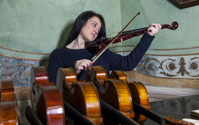 Fascinating violinist showing his collection of handcrafted violins at home