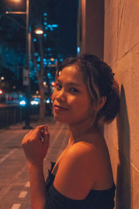 Portrait of young woman smoking cigarette at night