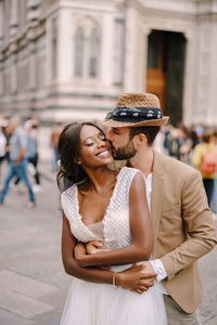 Young couple kissing on street in city