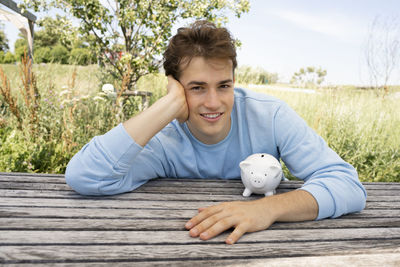 Side view of man sitting on boardwalk