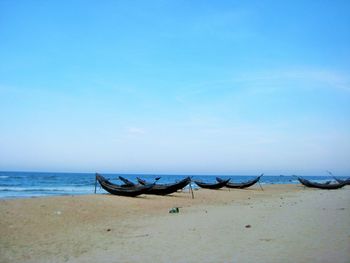 Deck chairs on beach against clear blue sky