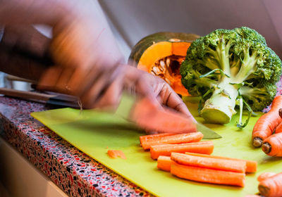 Midsection of person preparing food on cutting board