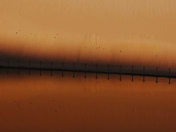 Scenic view of lake against orange sky