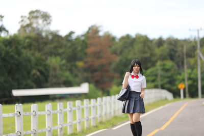 Rear view of woman walking on road