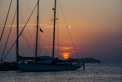 Sailboat sailing in sea against sky during sunset