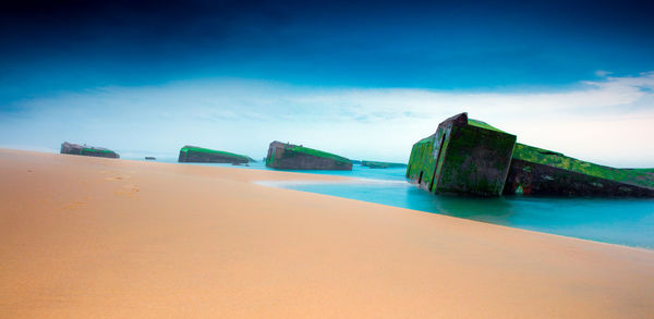 Scenic view of beach against blue sky