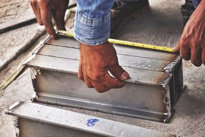 Low section of man working on metal