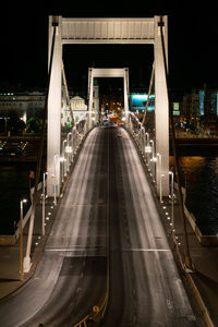 Illuminated bridge over city at night