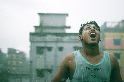 Portrait of man seen through wet glass window