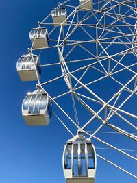 Low angle view of ferris wheel against clear blue sky