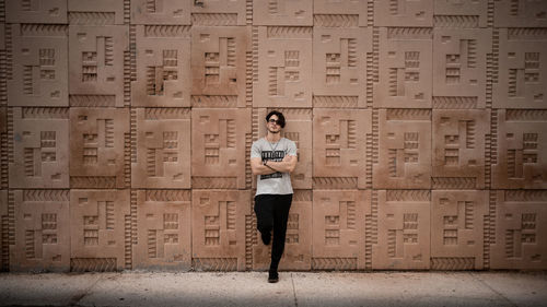 Portrait of man standing against wall