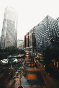 Modern buildings in city against sky during rainy season